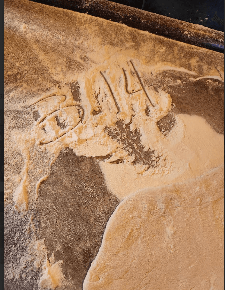 A playful message drawn in flour during pizza class
